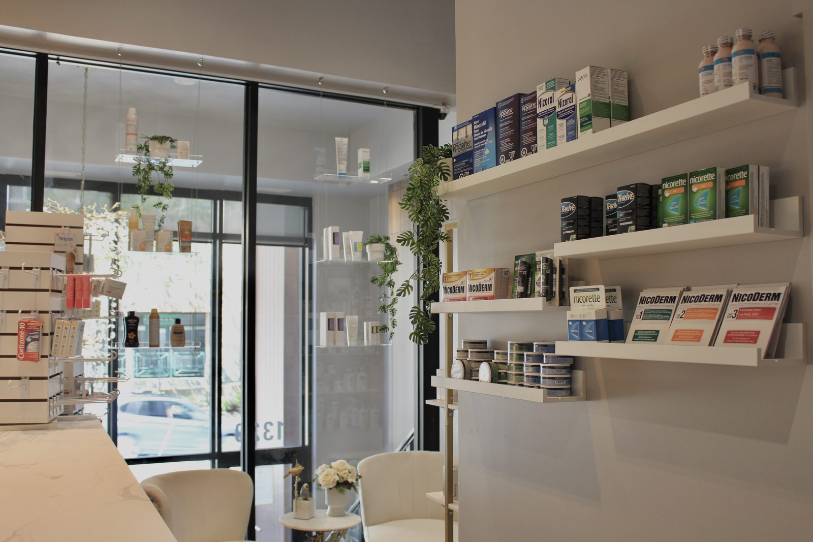 Consult corner at Cunard Pharmacy: white chairs by the glass entrance, plants and daylight
