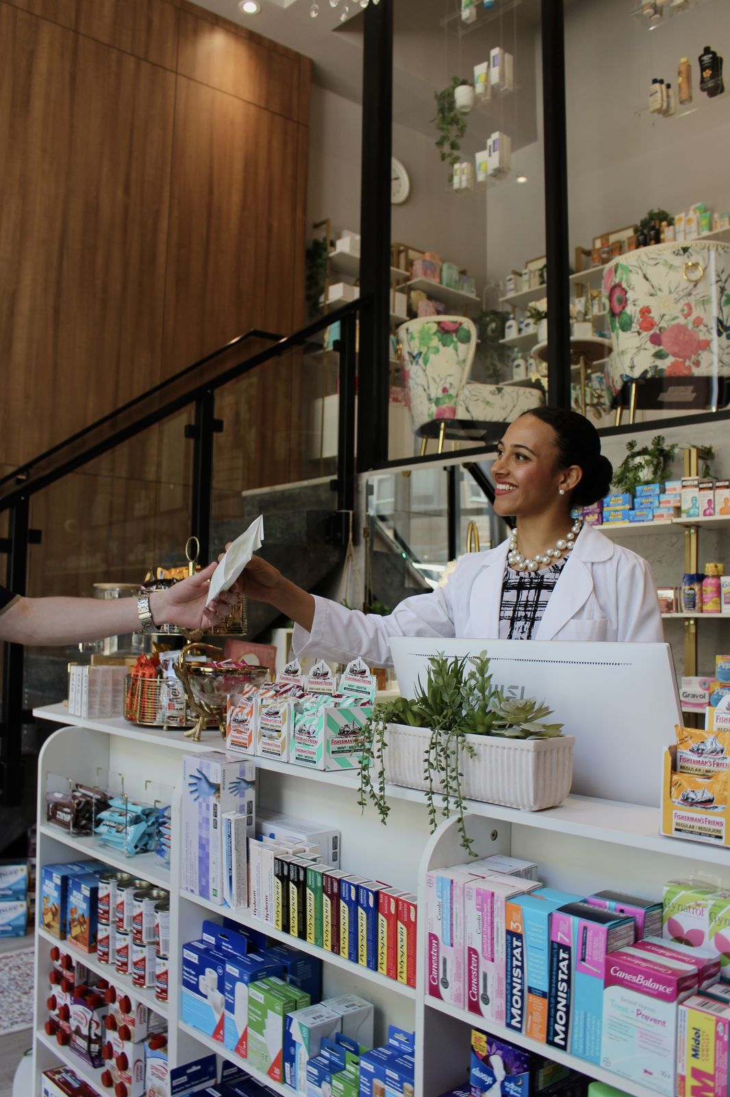 Cunard pharmacist handing a prescription bag across the counter